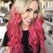 Омбре девушка с розовыми волнистыми волосами в салоне
