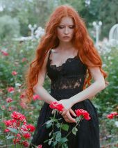 Рыжая девушка среди роз