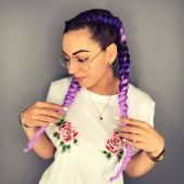 Девушка с лилово-фиолетовыми косами в очках и футболке с розами